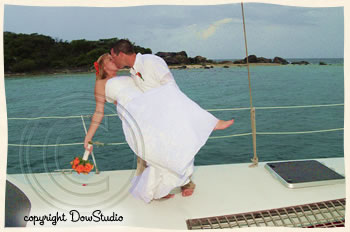 Groom dipping bride on sailboat.